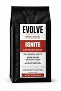 A 12 oz black bag of Evolve Bean Coffee Company's Ignite Espresso Blend dark roast coffee, featuring a white and red label on a white background.
